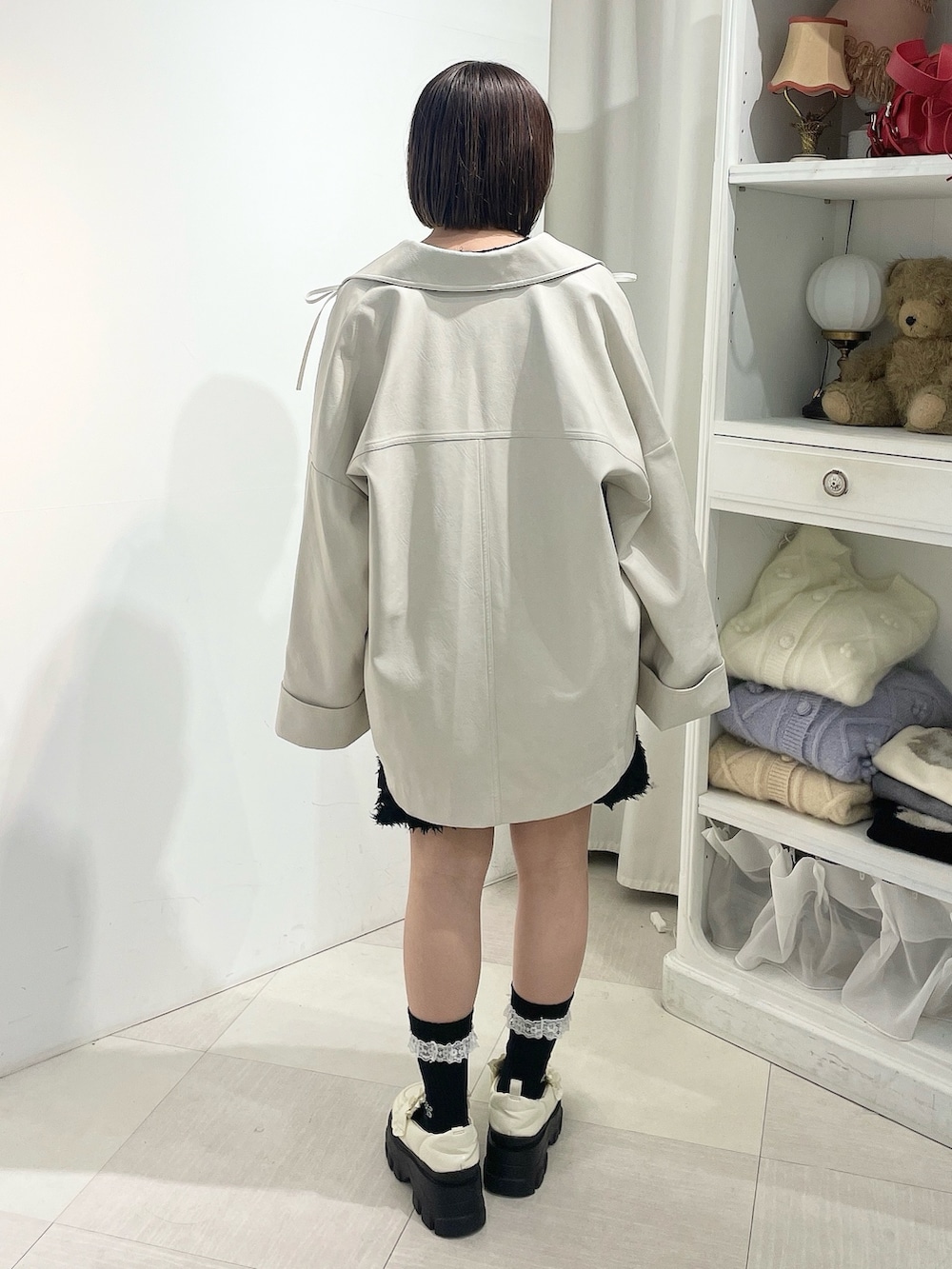 ホワイト系のブルゾン、ブラック系のワンピース、ホワイト系のローファーを着用したレディースの秋コーディネートの3枚目の写真