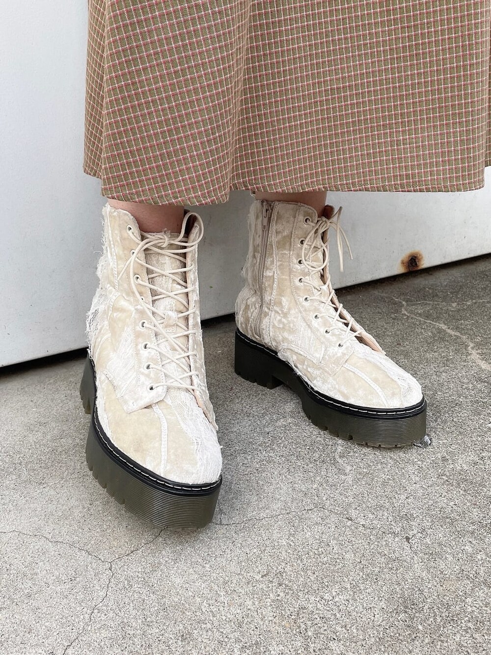 ホワイト系のブーツ、ブラック系のブルゾン、グリーン系のワンピースを着用したレディースの冬コーディネートの6枚目の写真