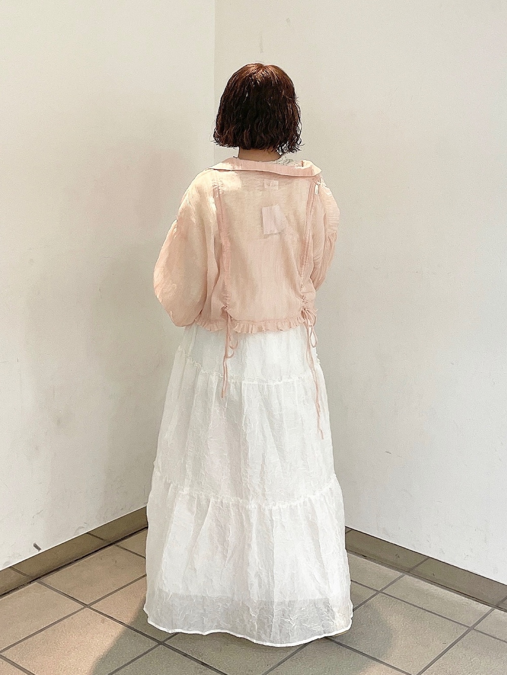 ホワイト系のワンピース、ピンク系のシャツ/ブラウス、ゴールド系のパンプスを着用したレディースの春コーディネートの3枚目の写真