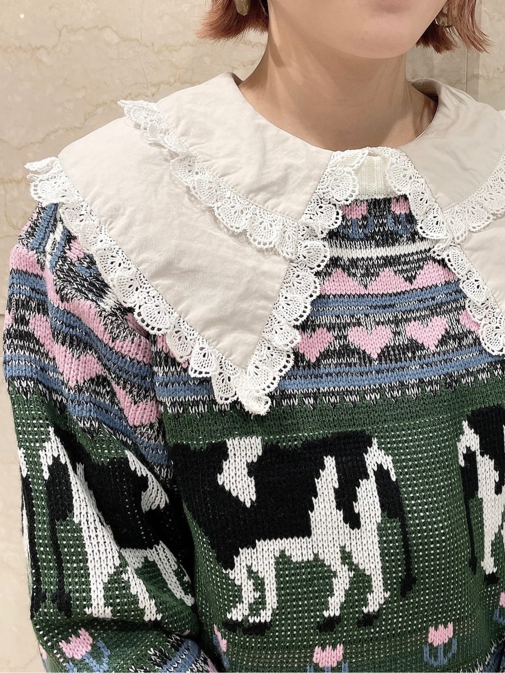 ホワイト系のニット/セーター、ベージュ系のスカート、ホワイト系のブーツを着用したレディースの秋コーディネートの4枚目の写真