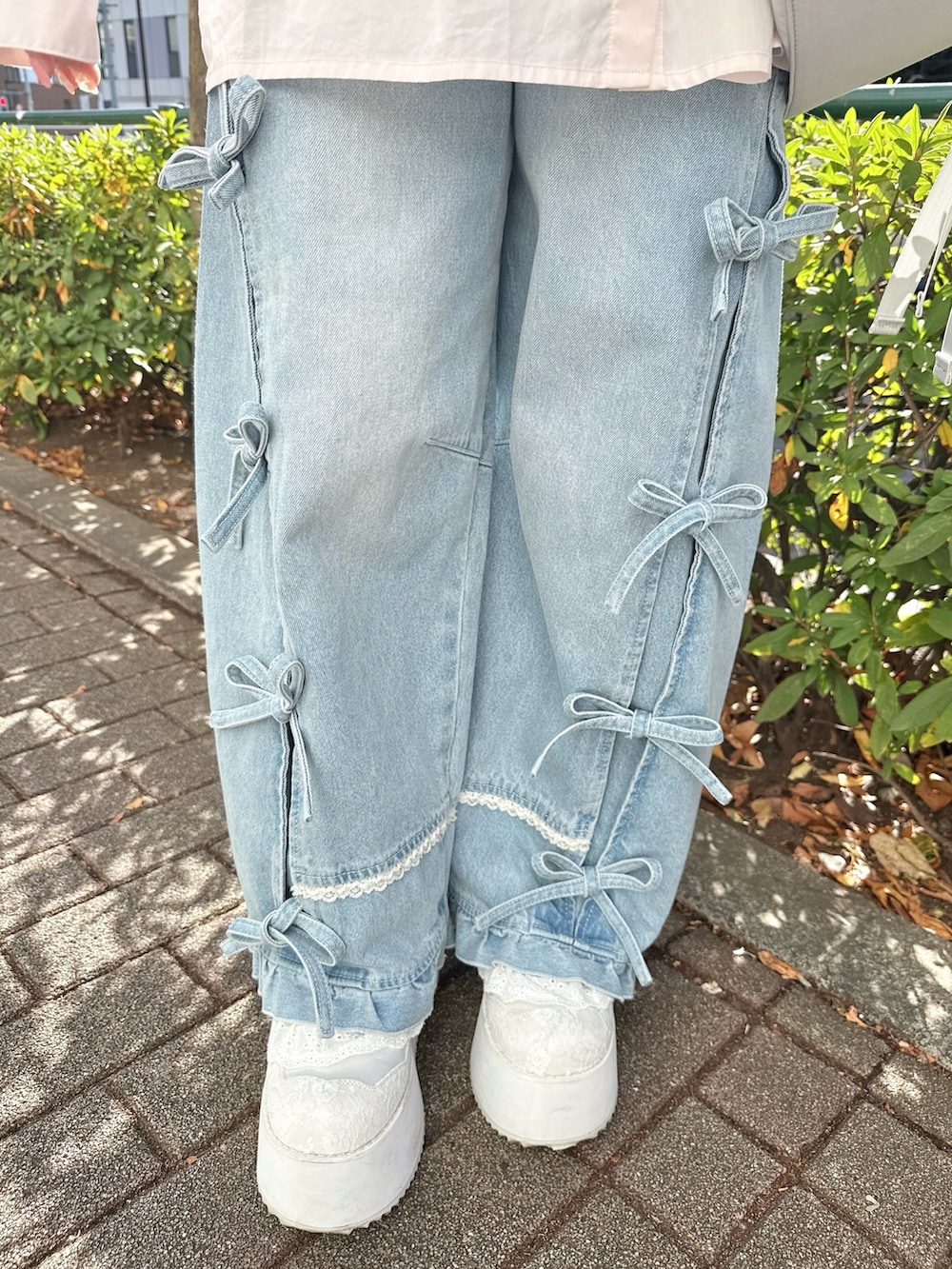 ピンク系のシャツ/ブラウス、グレー系のメッセンジャーバッグ、ブルー系のデニムパンツを着用したレディースの冬コーディネートの6枚目の写真