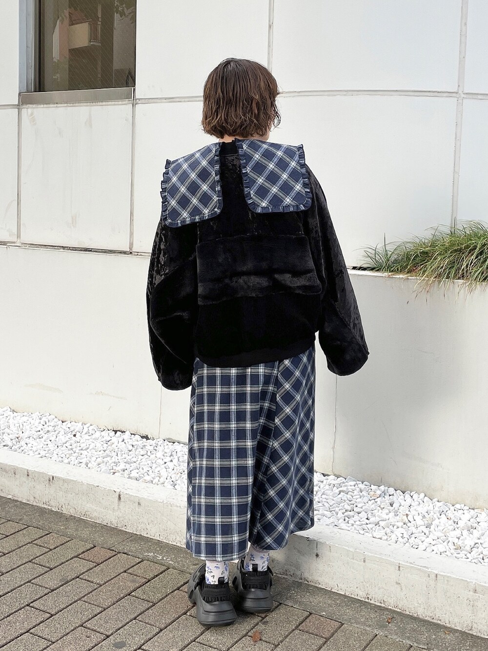 ブルー系のワンピース、ブラック系のブルゾン、ブラック系のスニーカーを着用したレディースの秋コーディネートの3枚目の写真