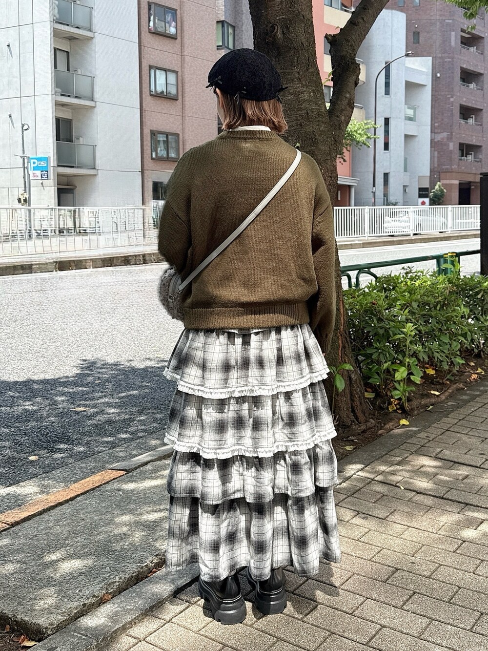 ホワイト系のシャツ/ブラウス、グレー系のショルダーバッグ、グリーン系のニット/セーターを着用したレディースの秋コーディネートの3枚目の写真