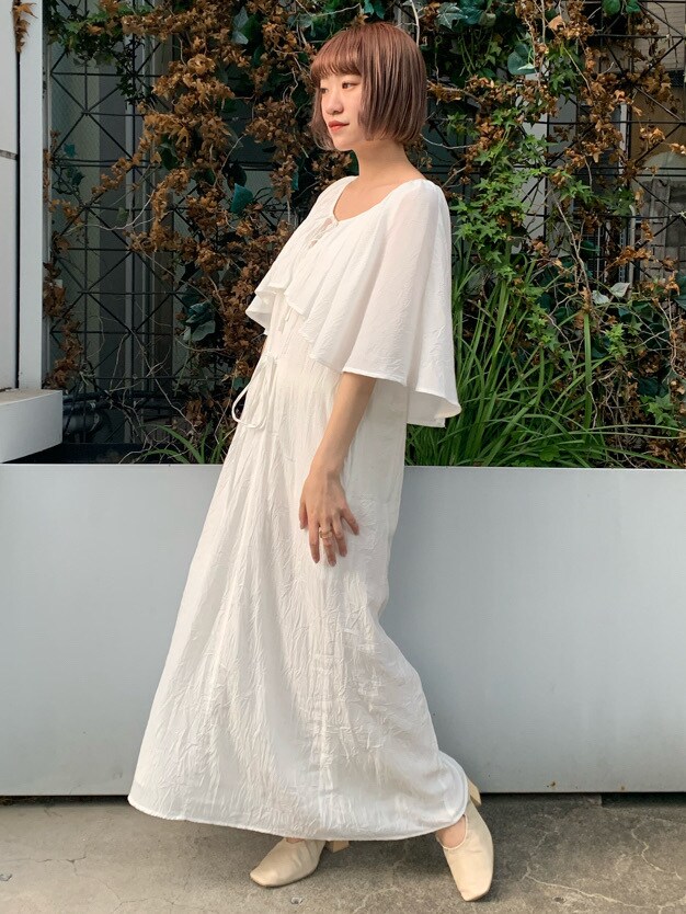 ホワイト系のパンプス、ホワイト系のワンピースを着用したレディースの春コーディネートの3枚目の写真