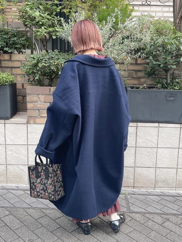 ブルー系のチェスターコート、レッド系のワンピース、その他のパンプスを着用したレディースの秋コーディネートの3枚目の写真