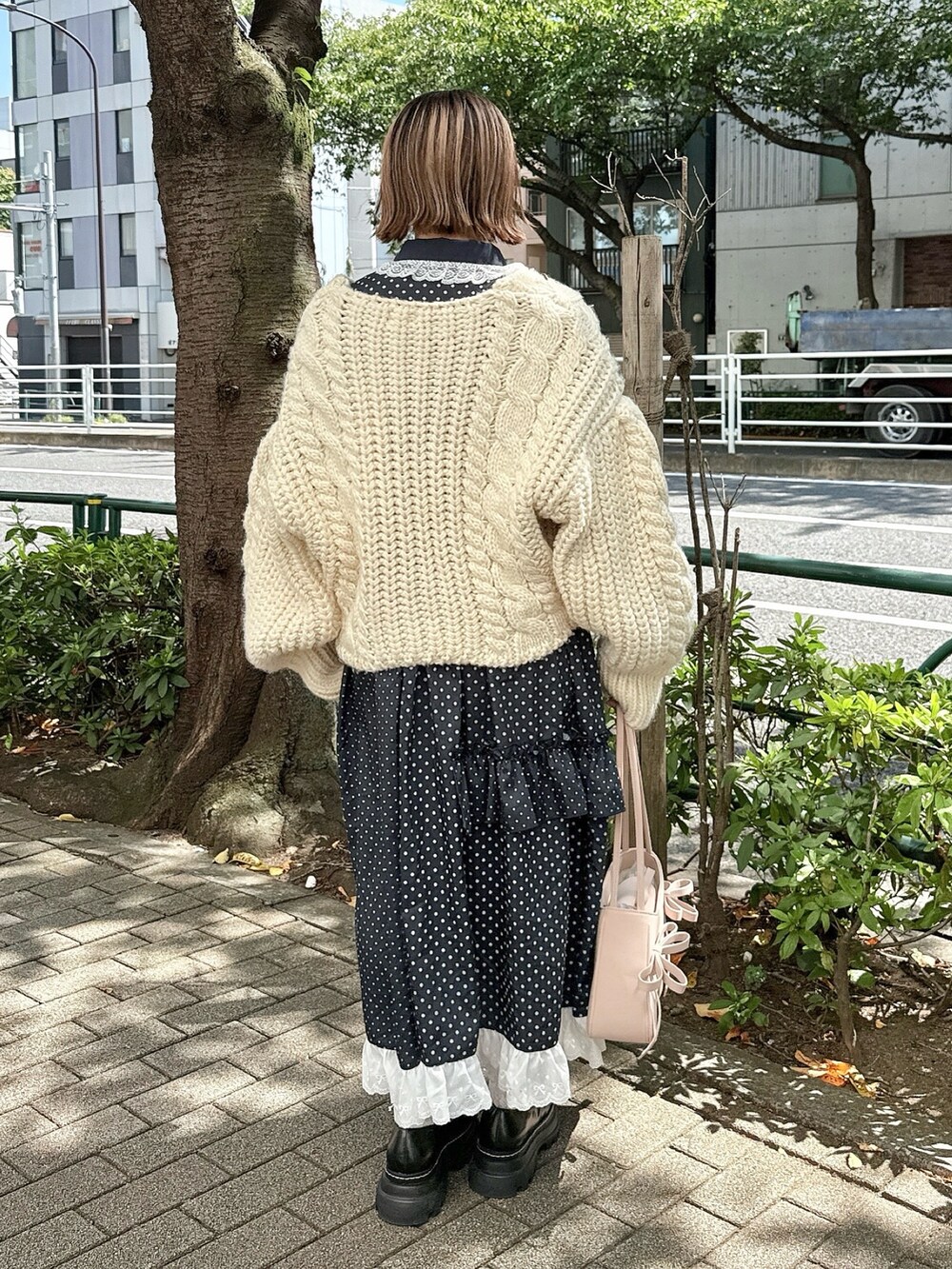 ホワイト系のカーディガン/ボレロ、ピンク系のハンドバッグ、ブラック系のローファーを着用したレディースの秋コーディネートの4枚目の写真