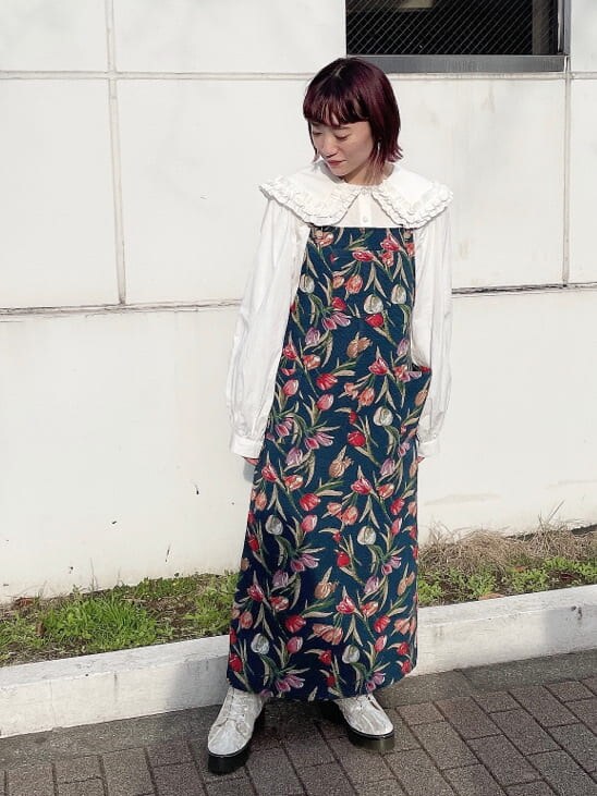 ホワイト系のブーツ、ブルー系のジャンパースカート、ホワイト系のカーディガン/ボレロを着用したレディースの冬コーディネートの4枚目の写真