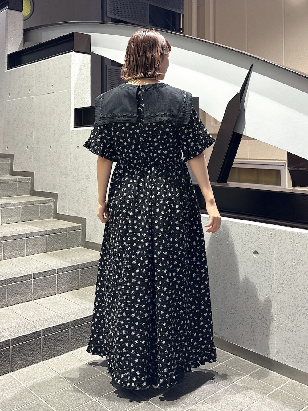 ブラック系のワンピース、ブラック系のスニーカー、ピンク系のネックレスを着用したレディースの春コーディネートの3枚目の写真