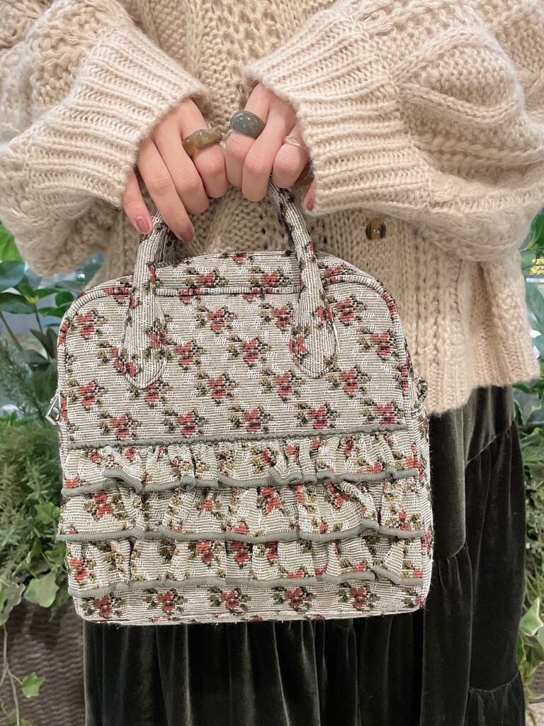 ベージュ系のスカート、ホワイト系のローファー、グリーン系のショルダーバッグを着用したレディースの冬コーディネートの7枚目の写真