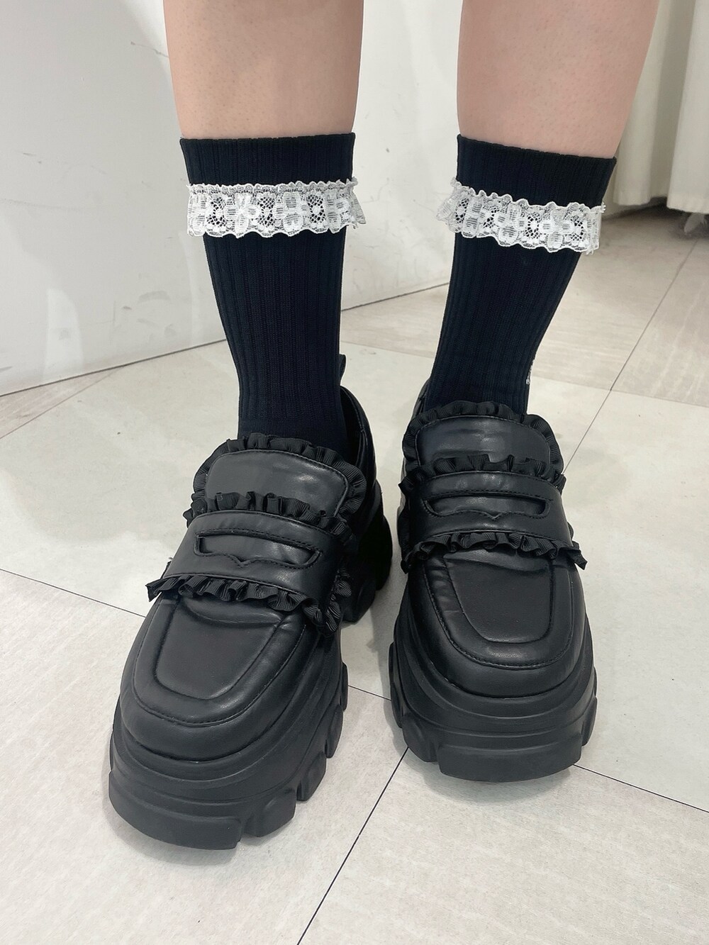 ブラック系のワンピース、レッド系のカーディガン/ボレロ、ブラック系のローファーを着用したレディースの秋コーディネートの7枚目の写真