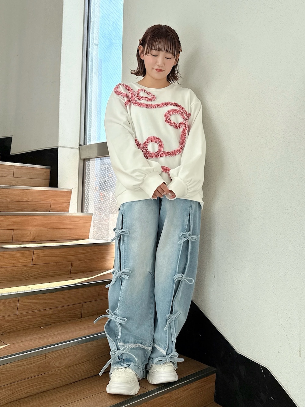 ホワイト系のブルゾン、ホワイト系のスウェット、ブルー系のデニムパンツを着用したレディースの冬コーディネートの6枚目の写真