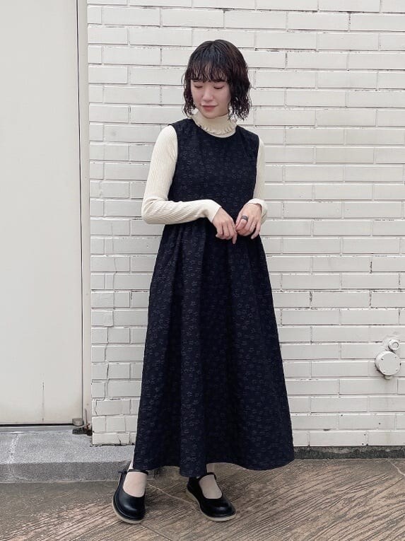 ブラック系のワンピース、ブラック系のパンプス、ホワイト系のニット/セーターを着用したレディースの秋コーディネートの5枚目の写真