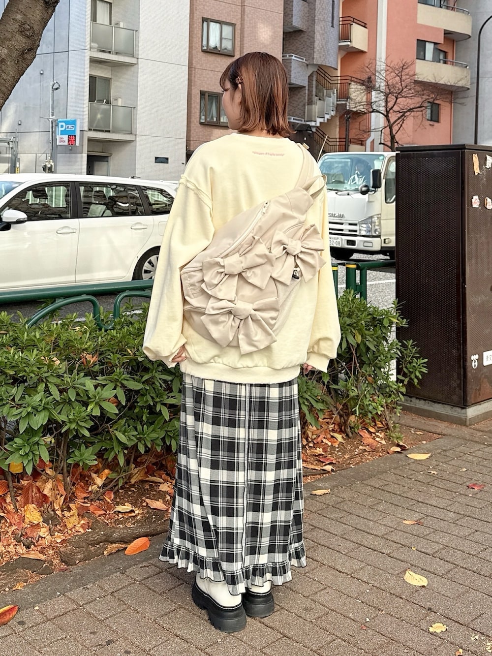 ベージュ系のスウェット、ベージュ系のショルダーバッグ、ベージュ系のスカートを着用したレディースの冬コーディネートの3枚目の写真