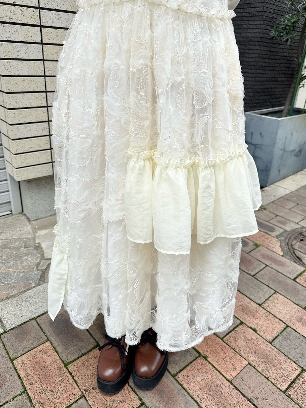 ベージュ系のTシャツ/カットソー、ホワイト系のワンピース、ホワイト系のスカートを着用したレディースの夏コーディネートの8枚目の写真