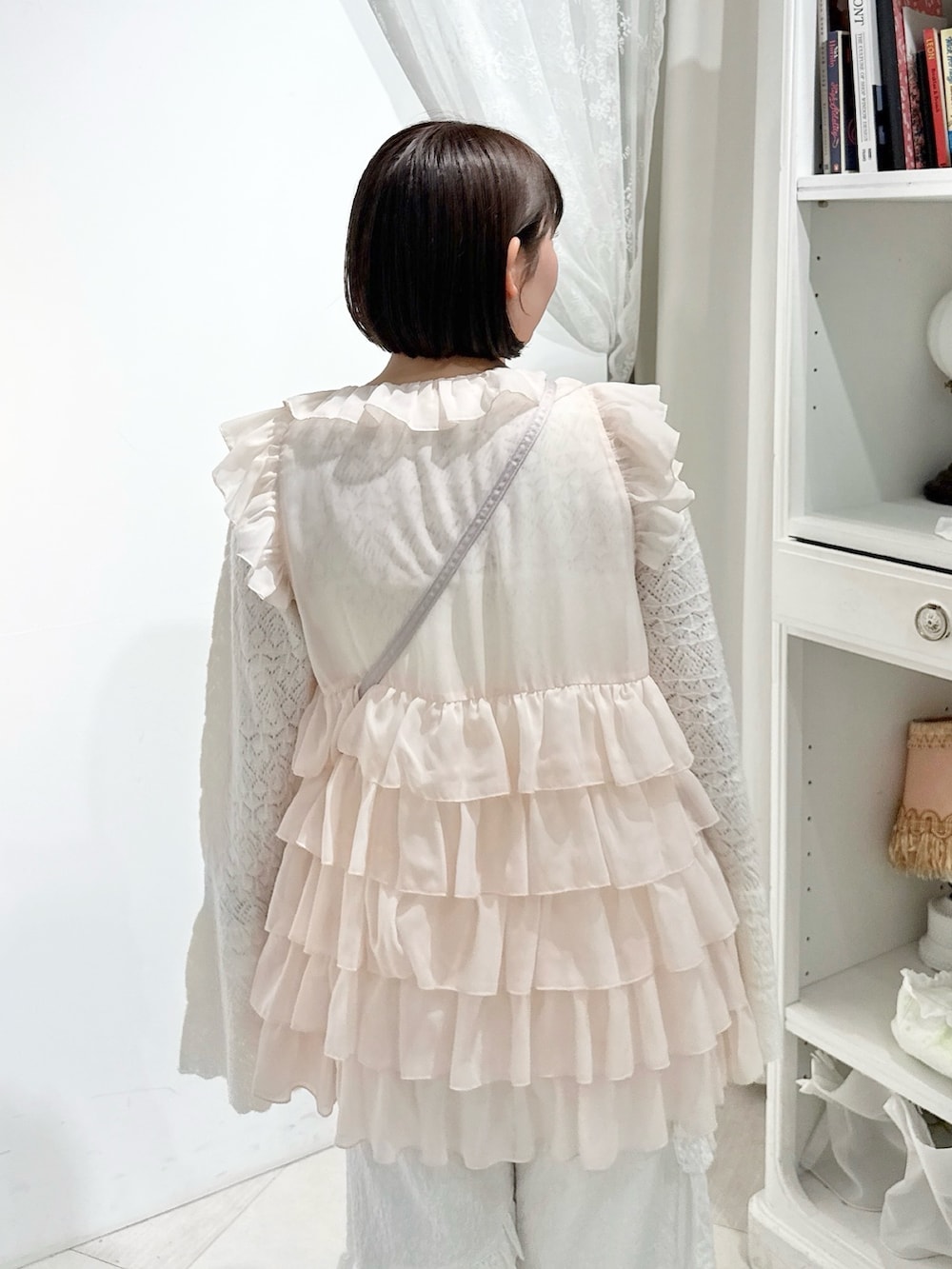 ピンク系のシャツ/ブラウス、ホワイト系のニット/セーター、ピンク系のハンドバッグを着用したレディースの夏コーディネートの5枚目の写真