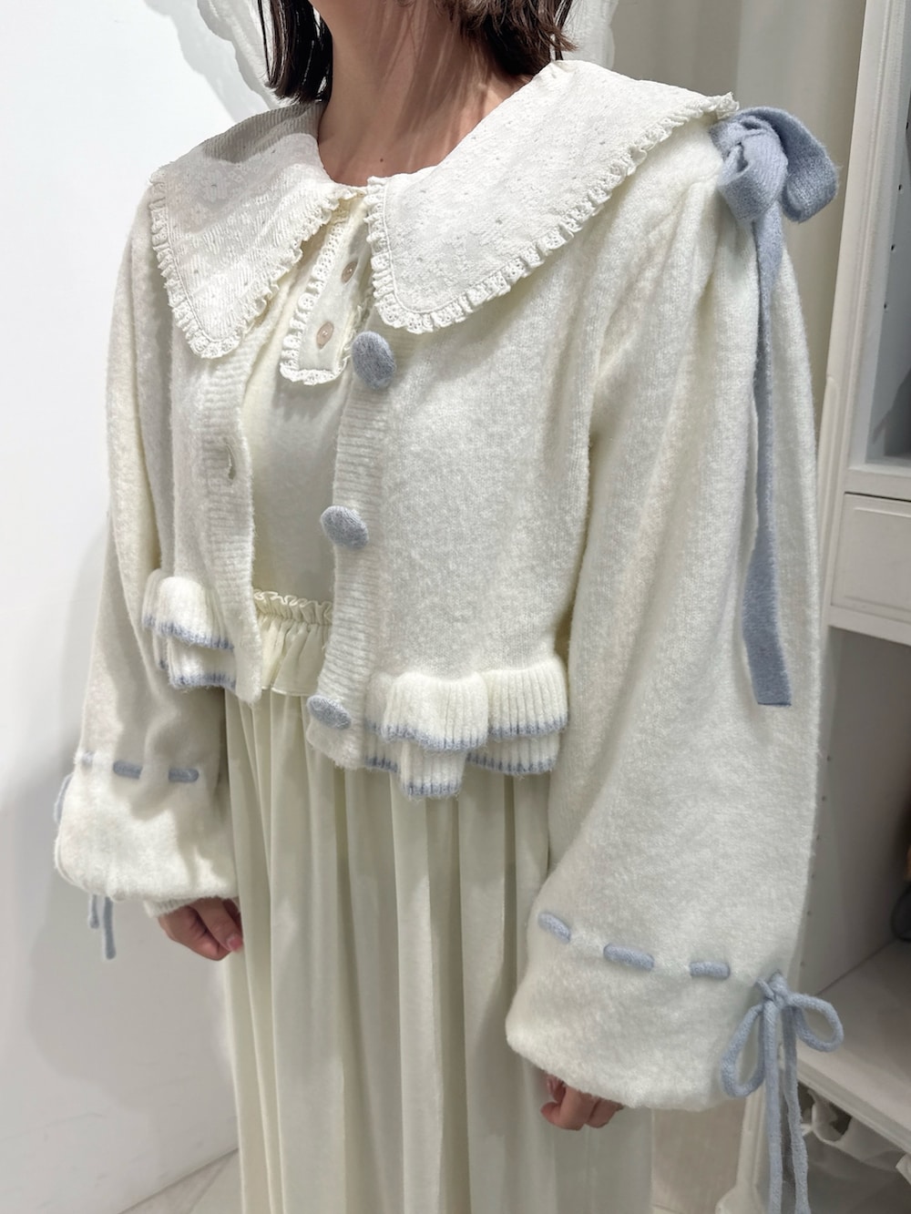 ホワイト系のワンピース、ホワイト系のカーディガン/ボレロ、ブルー系のハンドバッグを着用したレディースの秋コーディネートの8枚目の写真