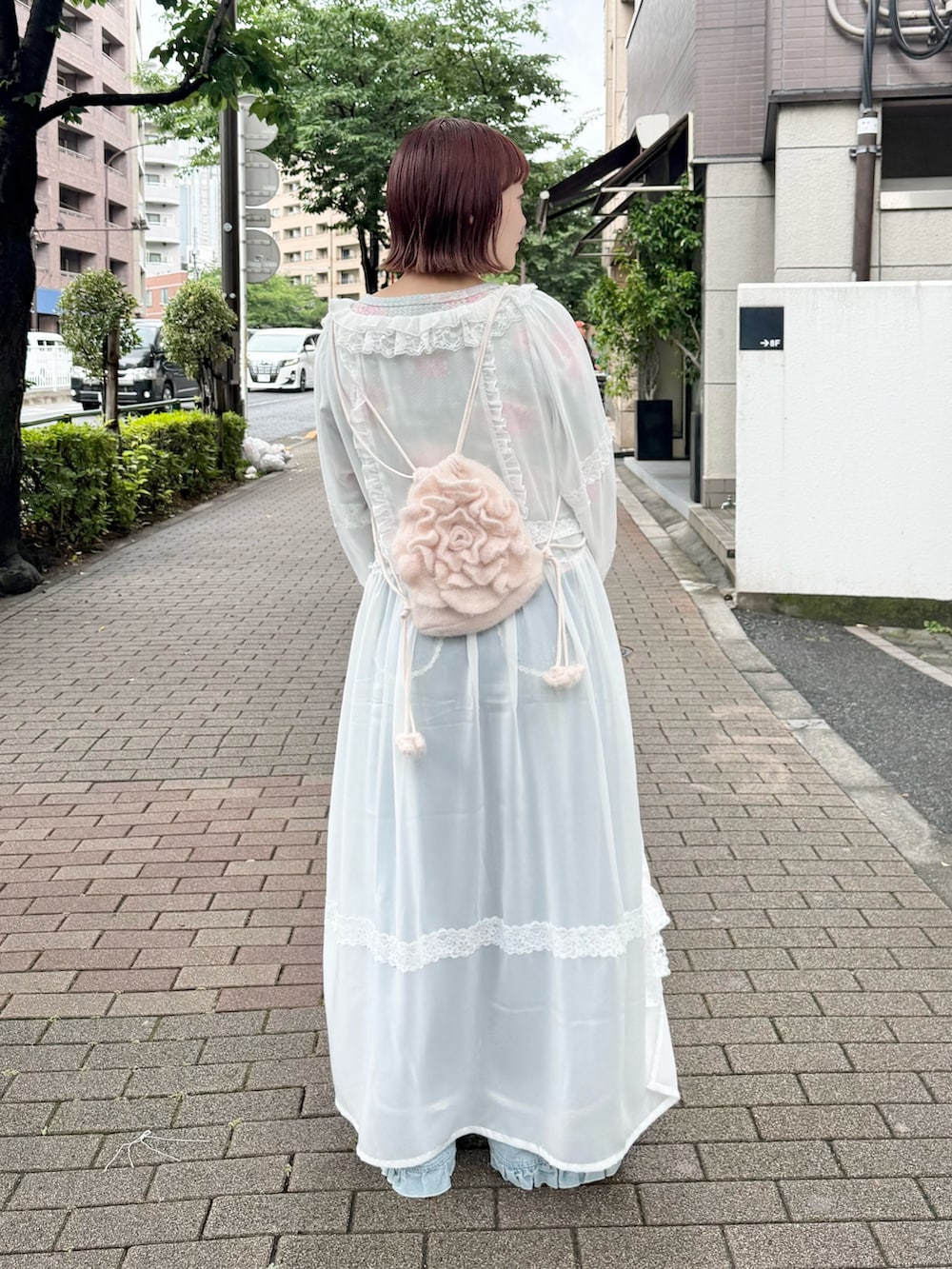 グリーン系のTシャツ/カットソー、ホワイト系のワンピース、ブルー系のデニムパンツを着用したレディースの夏コーディネートの3枚目の写真
