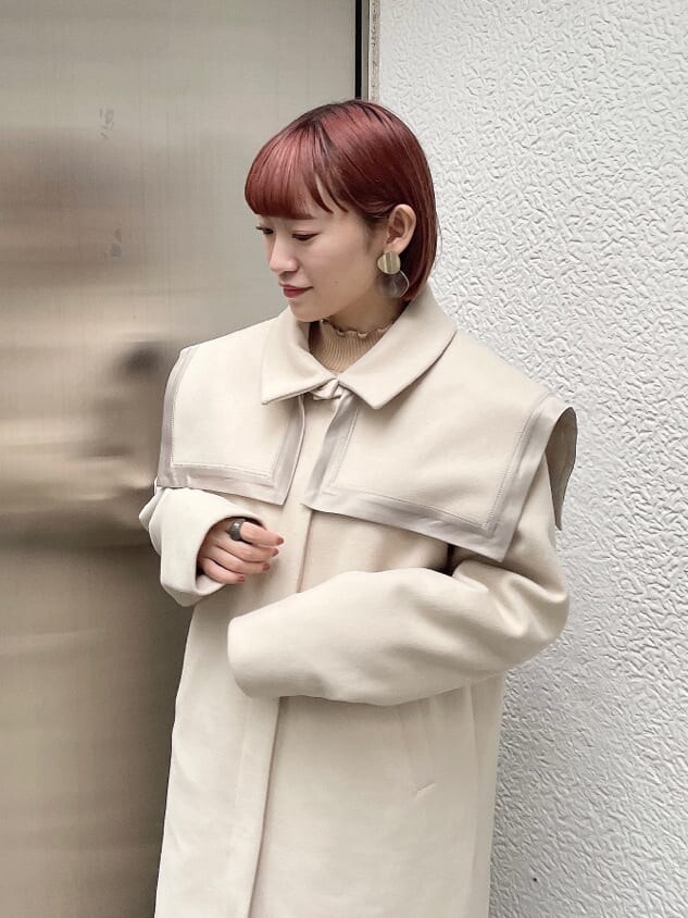 ホワイト系のニット/セーター、ホワイト系のその他アウター、ブラウン系のスカートを着用したレディースの秋コーディネートの3枚目の写真