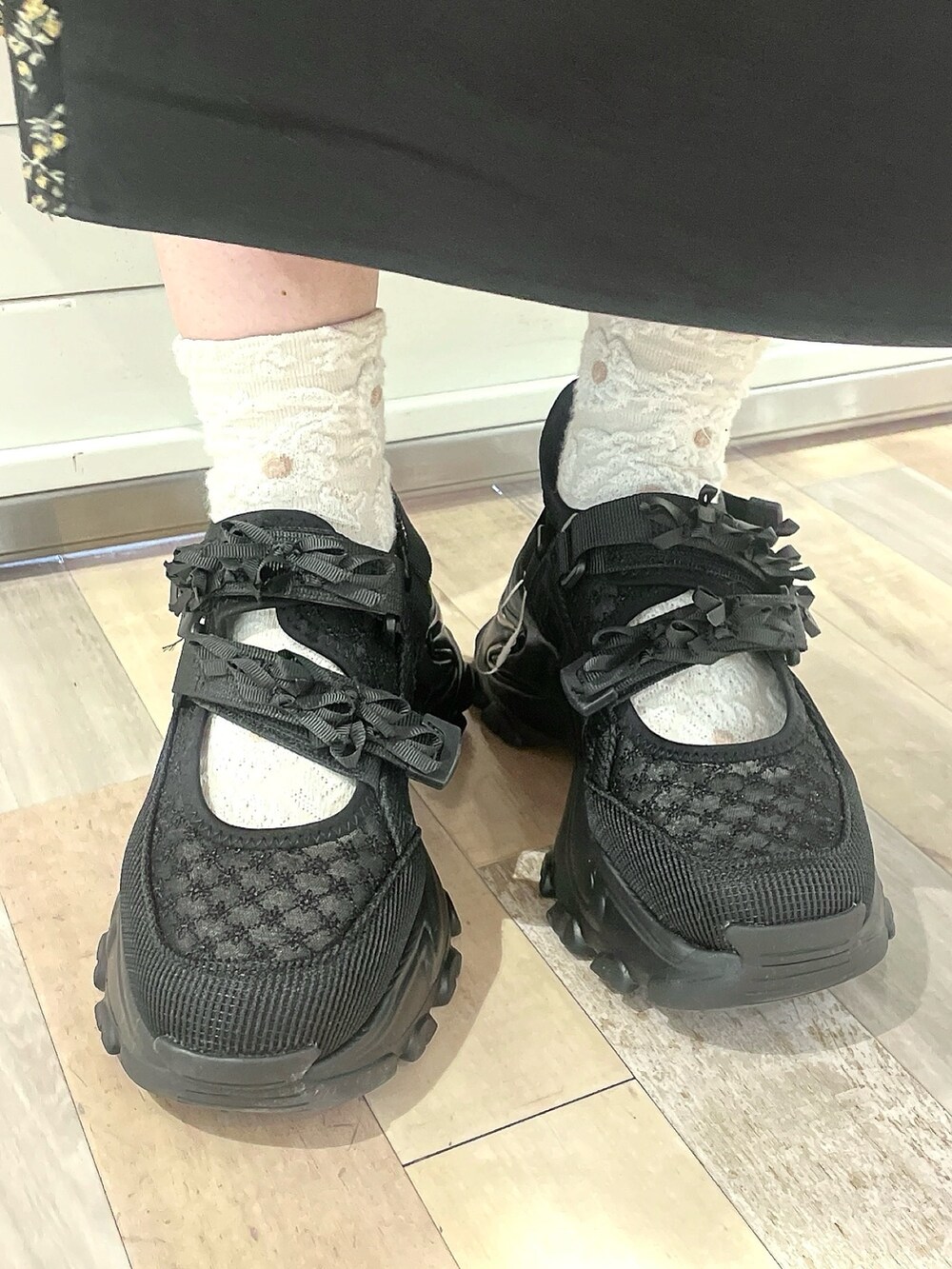 ブラック系のワンピース、ブラック系のスニーカーを着用したレディースの冬コーディネートの4枚目の写真