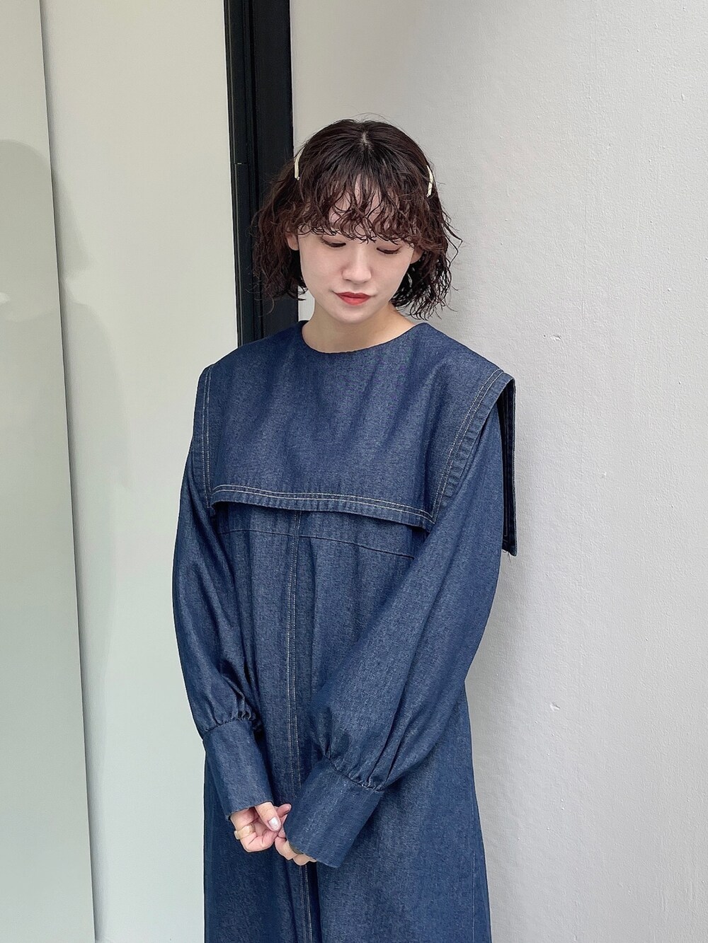 ホワイト系のトートバッグ、ベージュ系のブーツ、ブルー系のワンピースを着用したレディースの秋コーディネートの4枚目の写真