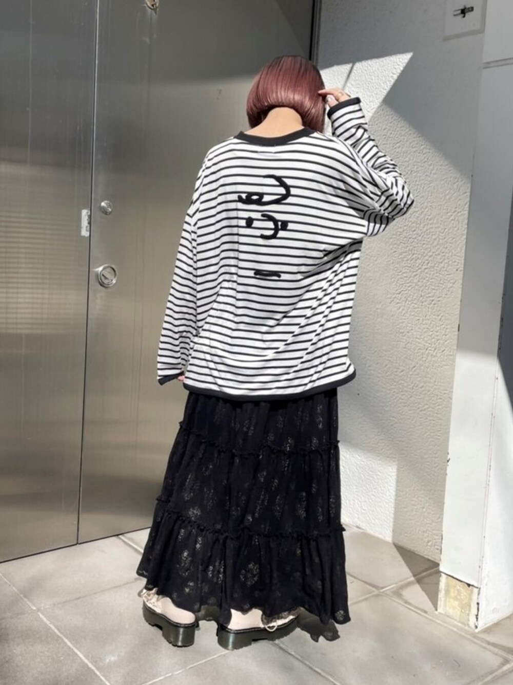 ホワイト系のその他シューズ、ブラック系のスカート、ブラック系のトートバッグを着用したレディースの春コーディネートの3枚目の写真