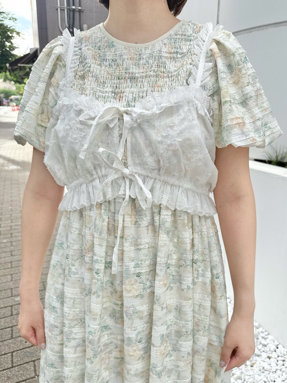 イエロー系のワンピース、ホワイト系のシャツ/ブラウス、ホワイト系のスニーカーを着用したレディースの夏コーディネートの6枚目の写真