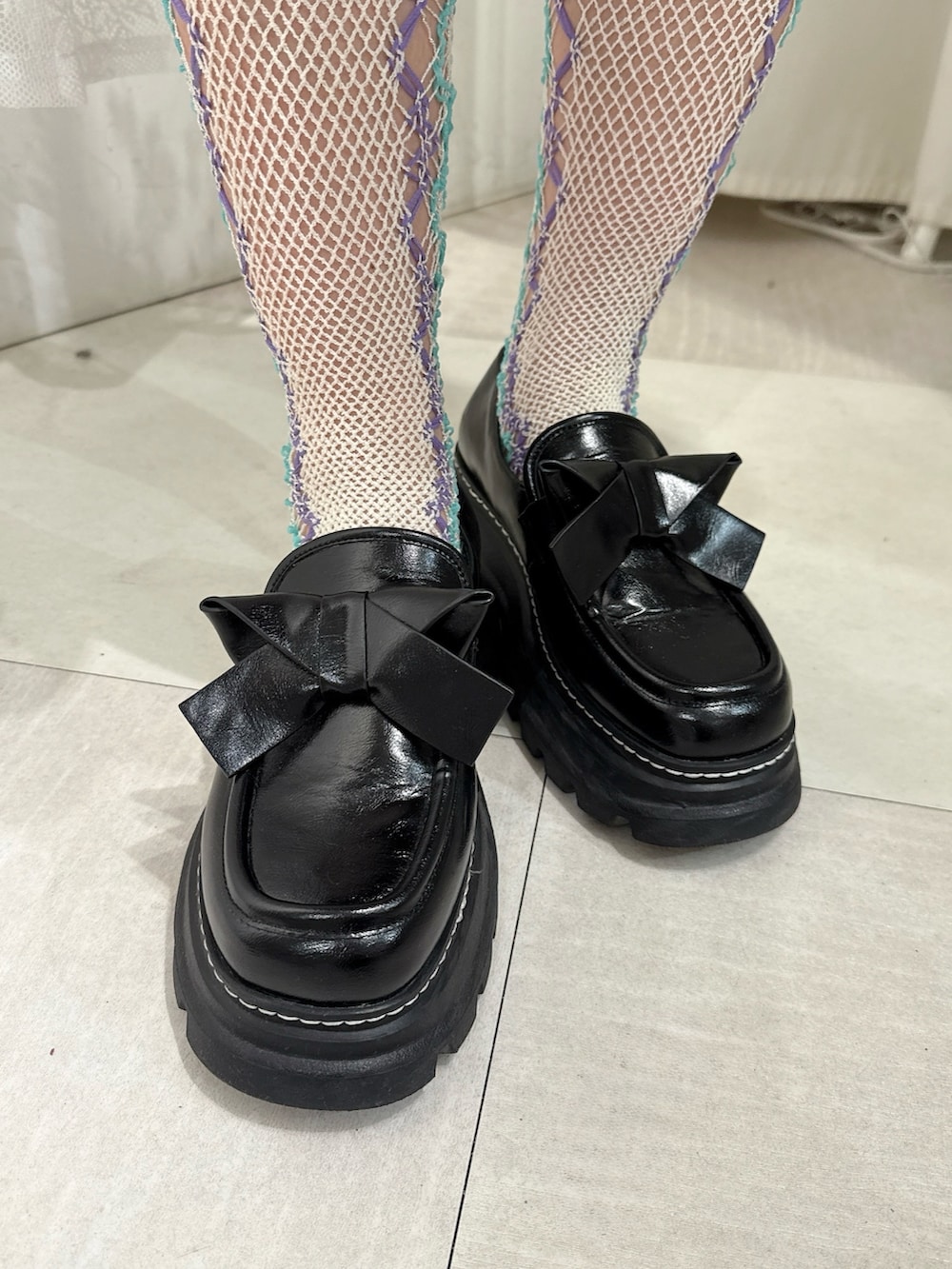 ブラック系のワンピース、ブラック系のカーディガン/ボレロ、ブラック系のローファーを着用したレディースの秋コーディネートの7枚目の写真