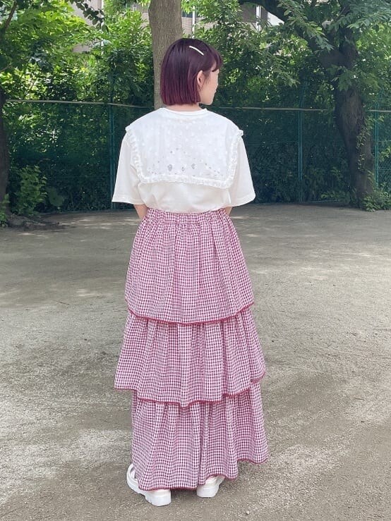 ホワイト系のサンダル、レッド系のスカート、ホワイト系のTシャツ/カットソーを着用したレディースの夏コーディネートの3枚目の写真