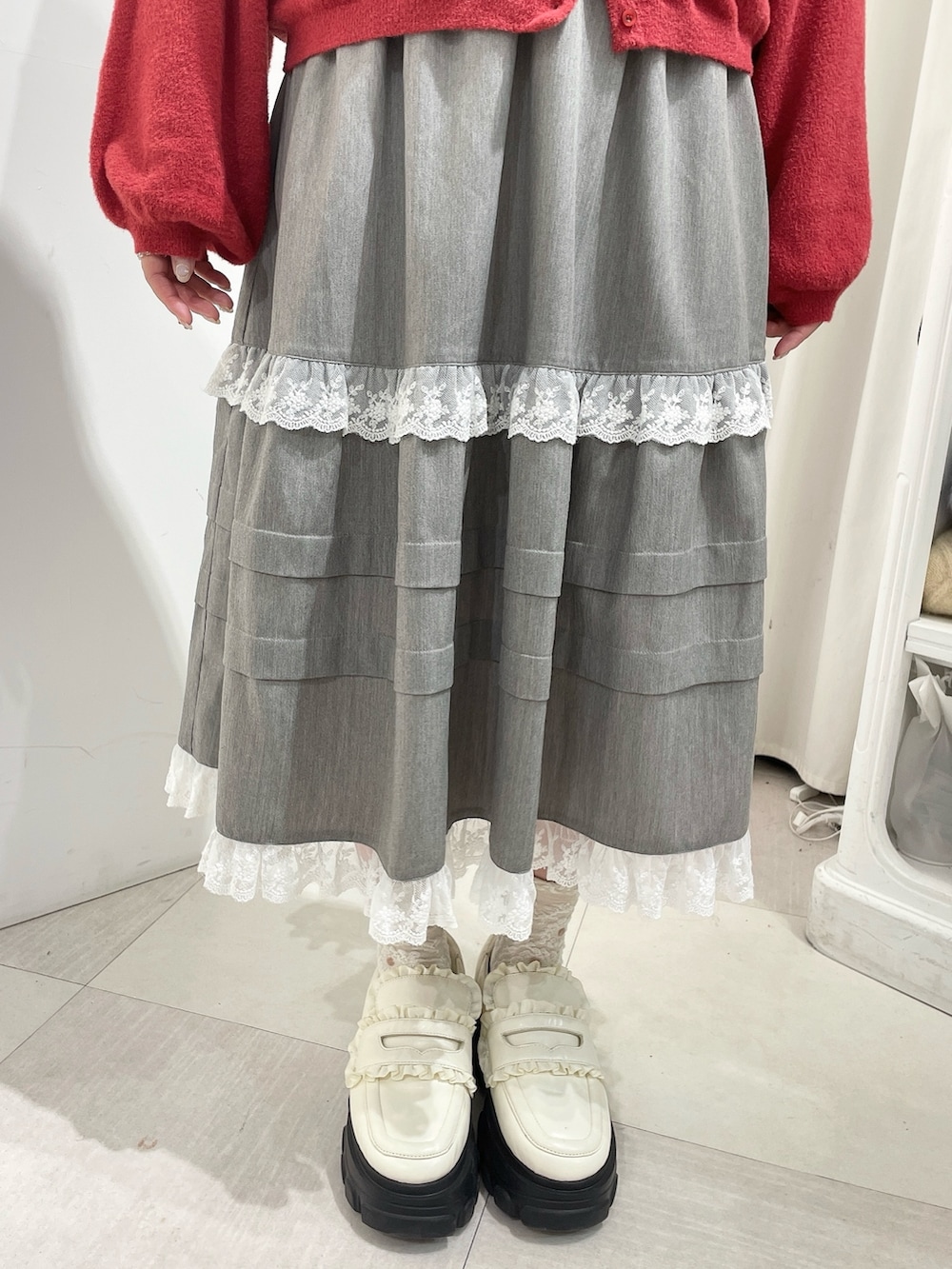 ホワイト系のシャツ/ブラウス、レッド系のカーディガン/ボレロ、グレー系のスカートを着用したレディースの秋コーディネートの7枚目の写真