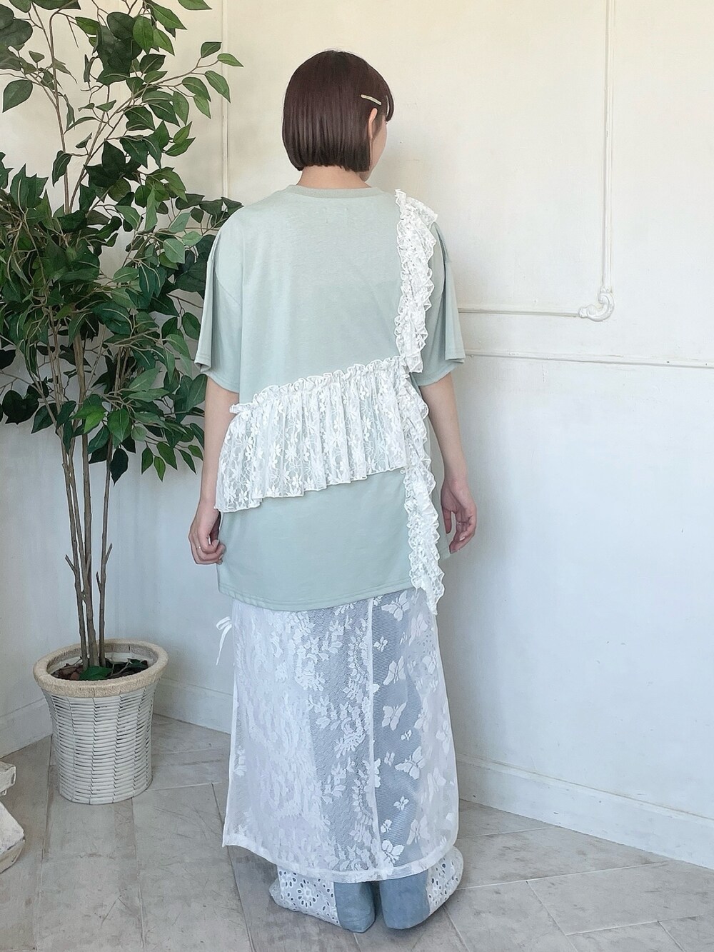 グリーン系のTシャツ/カットソー、ブルー系のデニムパンツ、ホワイト系のスカートを着用したレディースの春コーディネートの3枚目の写真