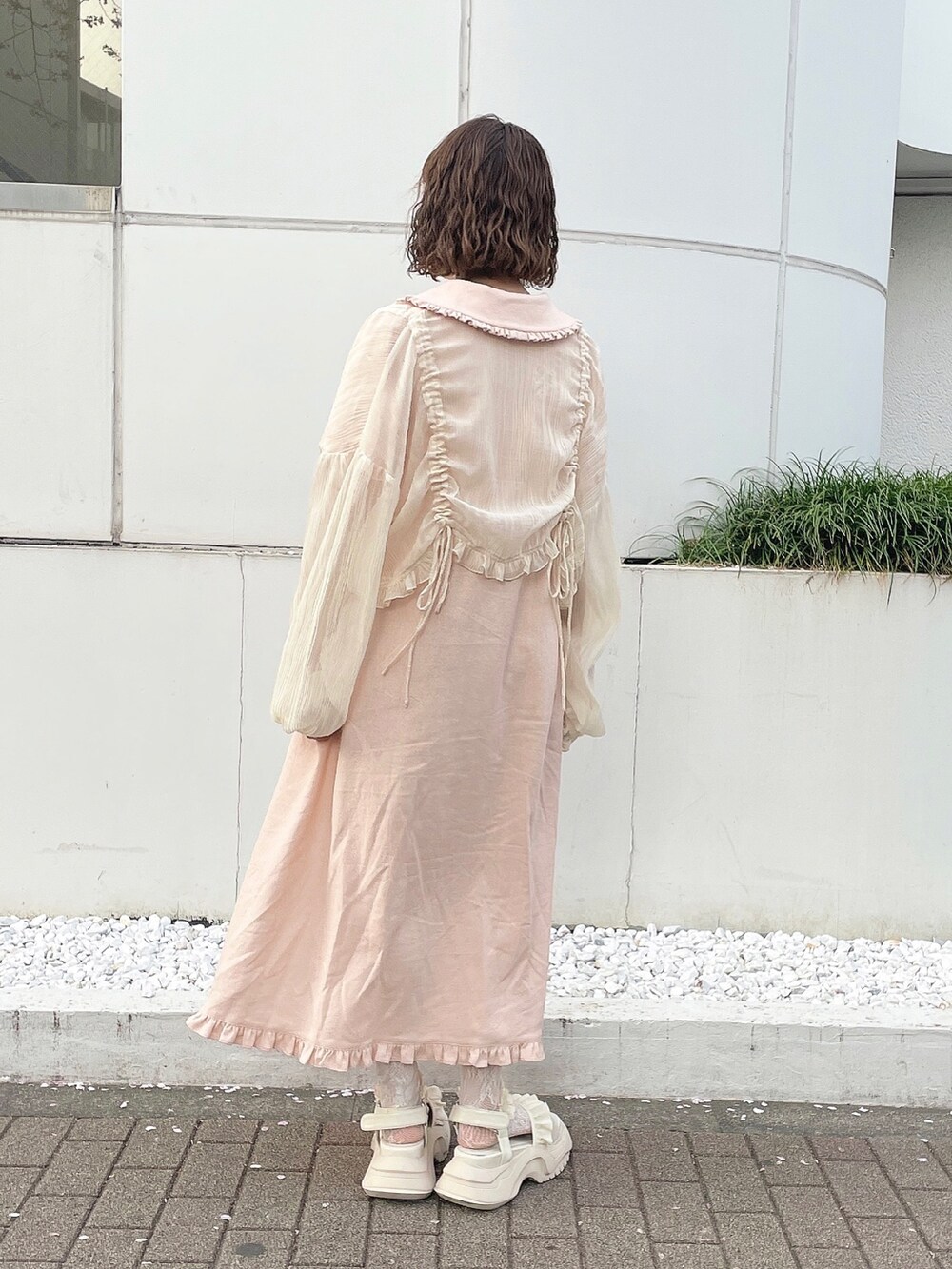 ベージュ系のシャツ/ブラウス、ピンク系のワンピース、ホワイト系のサンダルを着用したレディースの春コーディネートの2枚目の写真