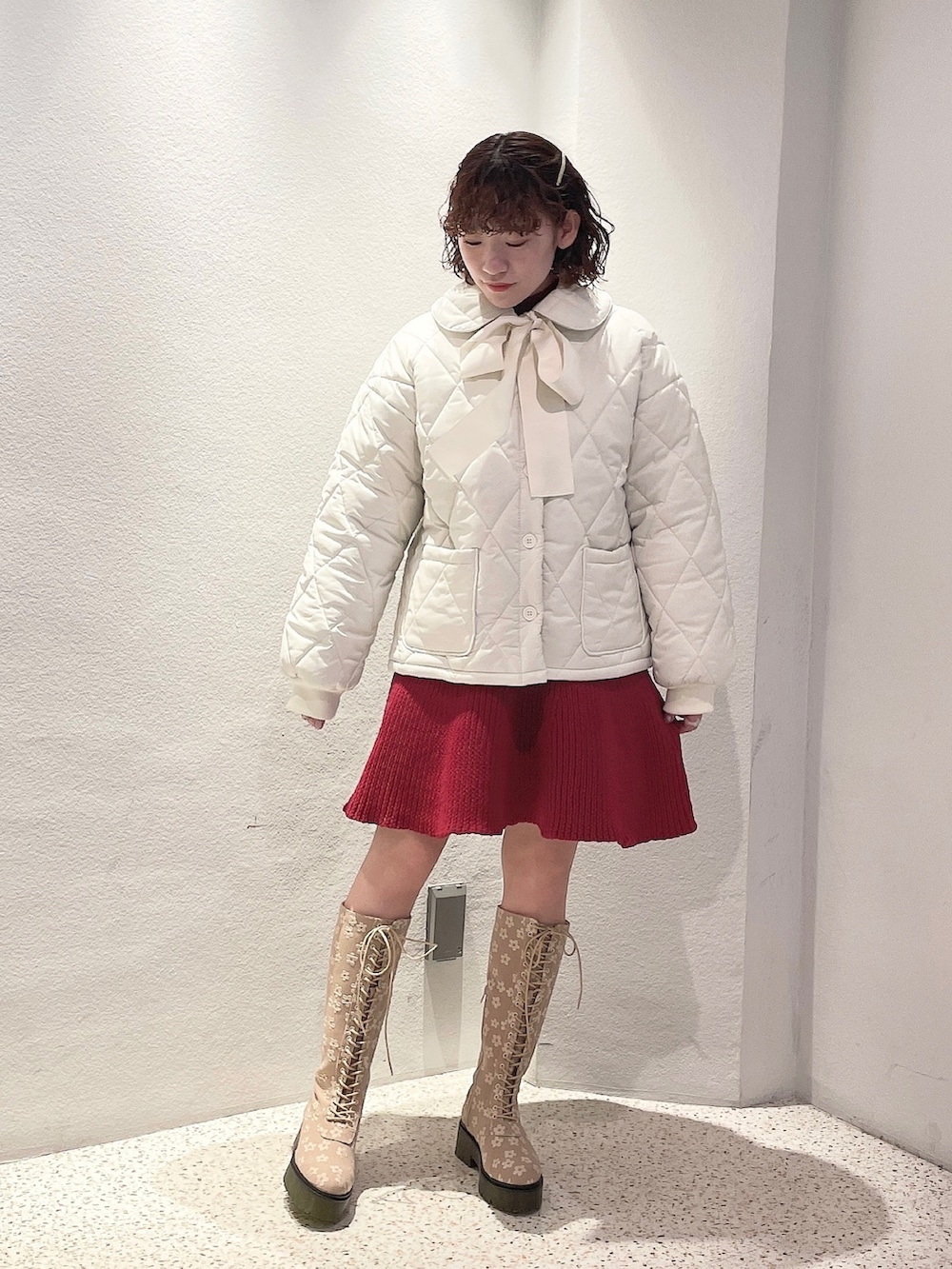 ホワイト系のその他アウター、レッド系のワンピース、ベージュ系のブーツを着用したレディースの冬コーディネートの2枚目の写真