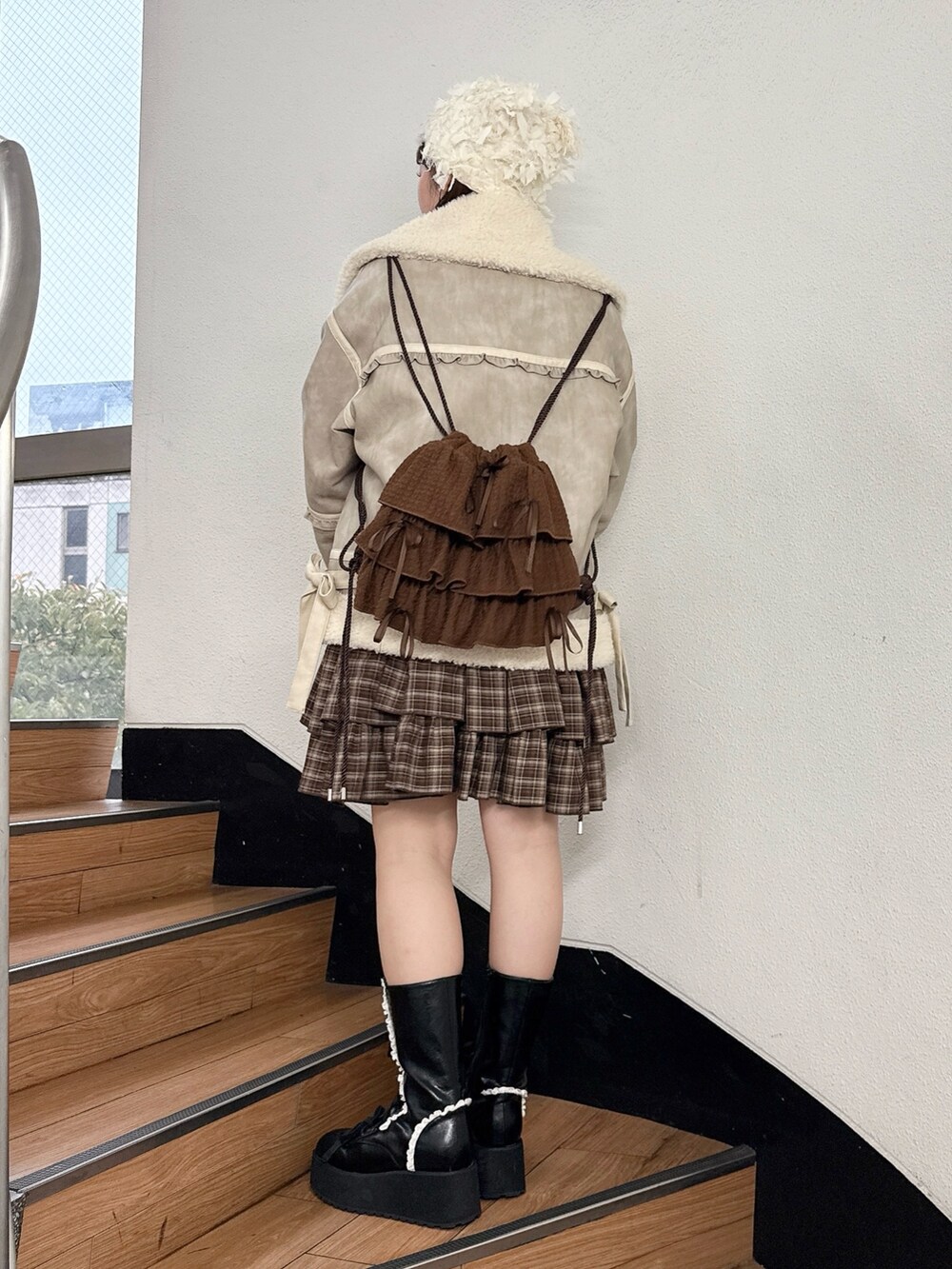 ブラウン系のワンピース、ベージュ系のムートンコート、ベージュ系のスウェットを着用したレディースの秋コーディネートの3枚目の写真