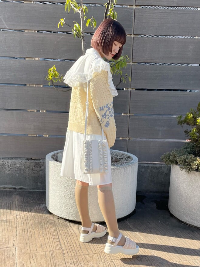 ホワイト系のカーディガン/ボレロ、ホワイト系のワンピース、ホワイト系のサンダルを着用したレディースの春コーディネートの2枚目の写真
