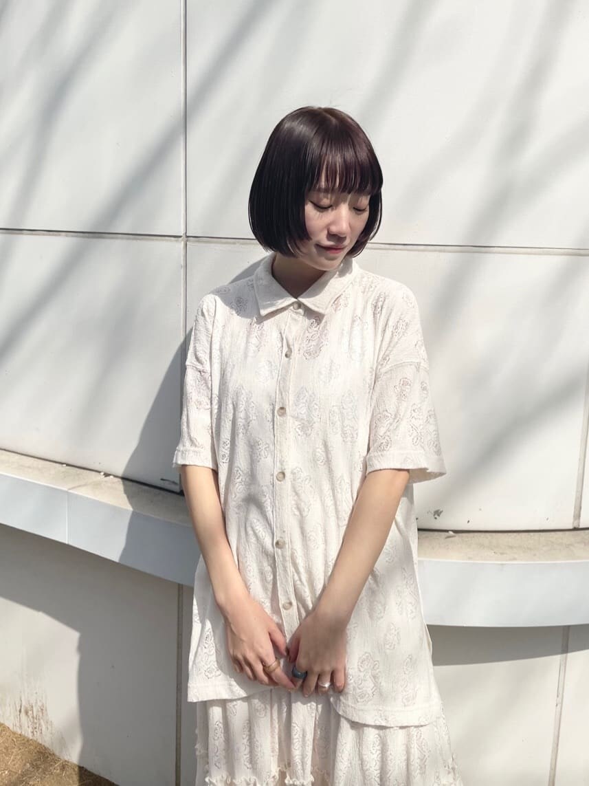 ホワイト系のスカート、ベージュ系のパンプス、ピンク系のハンドバッグを着用したレディースの春コーディネートの4枚目の写真