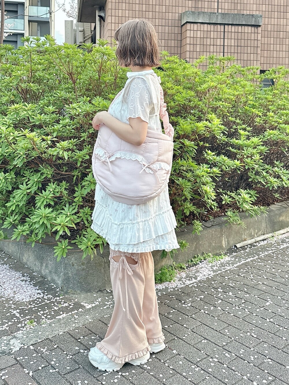 ピンク系のショルダーバッグ、ホワイト系のTシャツ/カットソー、ピンク系のワンピースを着用したレディースの春コーディネートの4枚目の写真