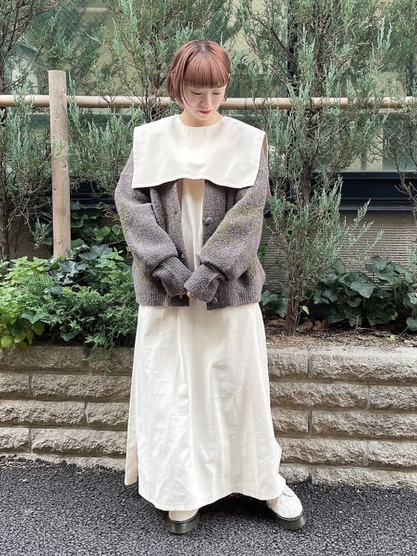 ホワイト系のワンピース、グレー系のカーディガン/ボレロ、ホワイト系のブーツを着用したレディースの秋コーディネートの2枚目の写真