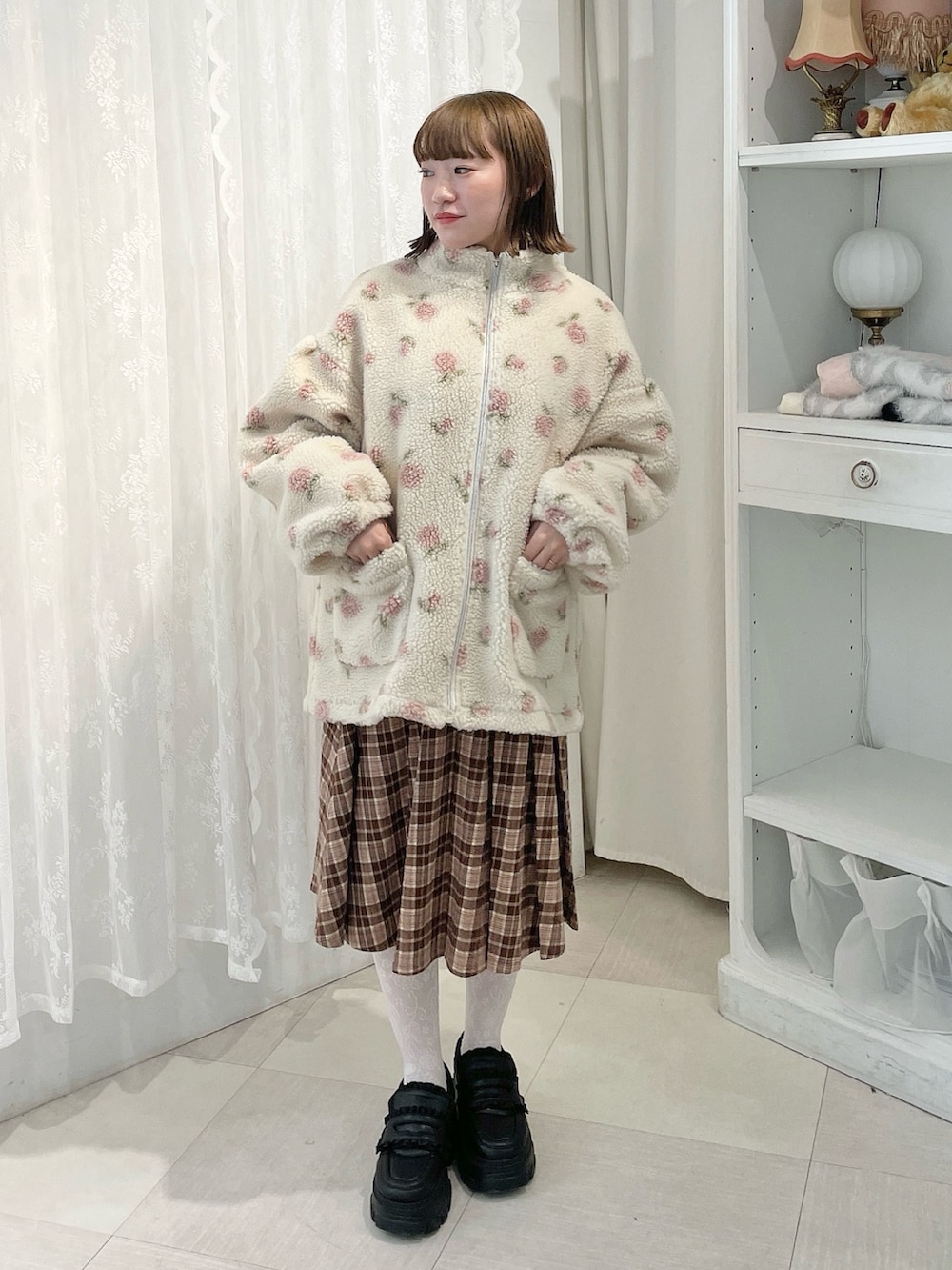 ホワイト系のスウェット、ピンク系のブルゾン、ブラウン系のスカートを着用したレディースの秋コーディネートの4枚目の写真