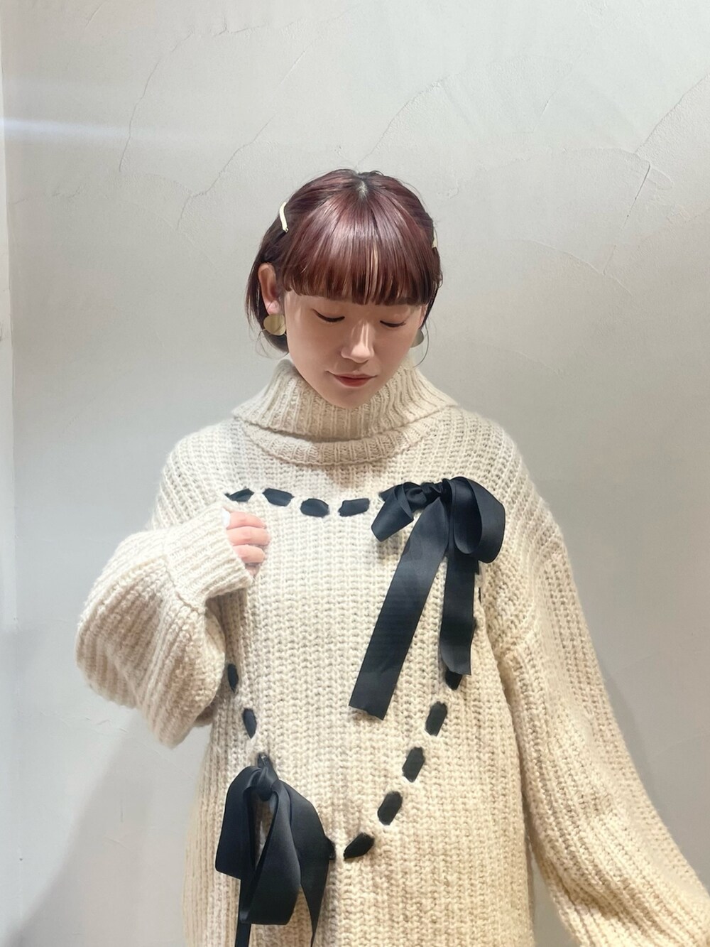 ホワイト系のニット/セーター、ブラウン系のパンプス、ホワイト系のスカートを着用したレディースの冬コーディネートの3枚目の写真