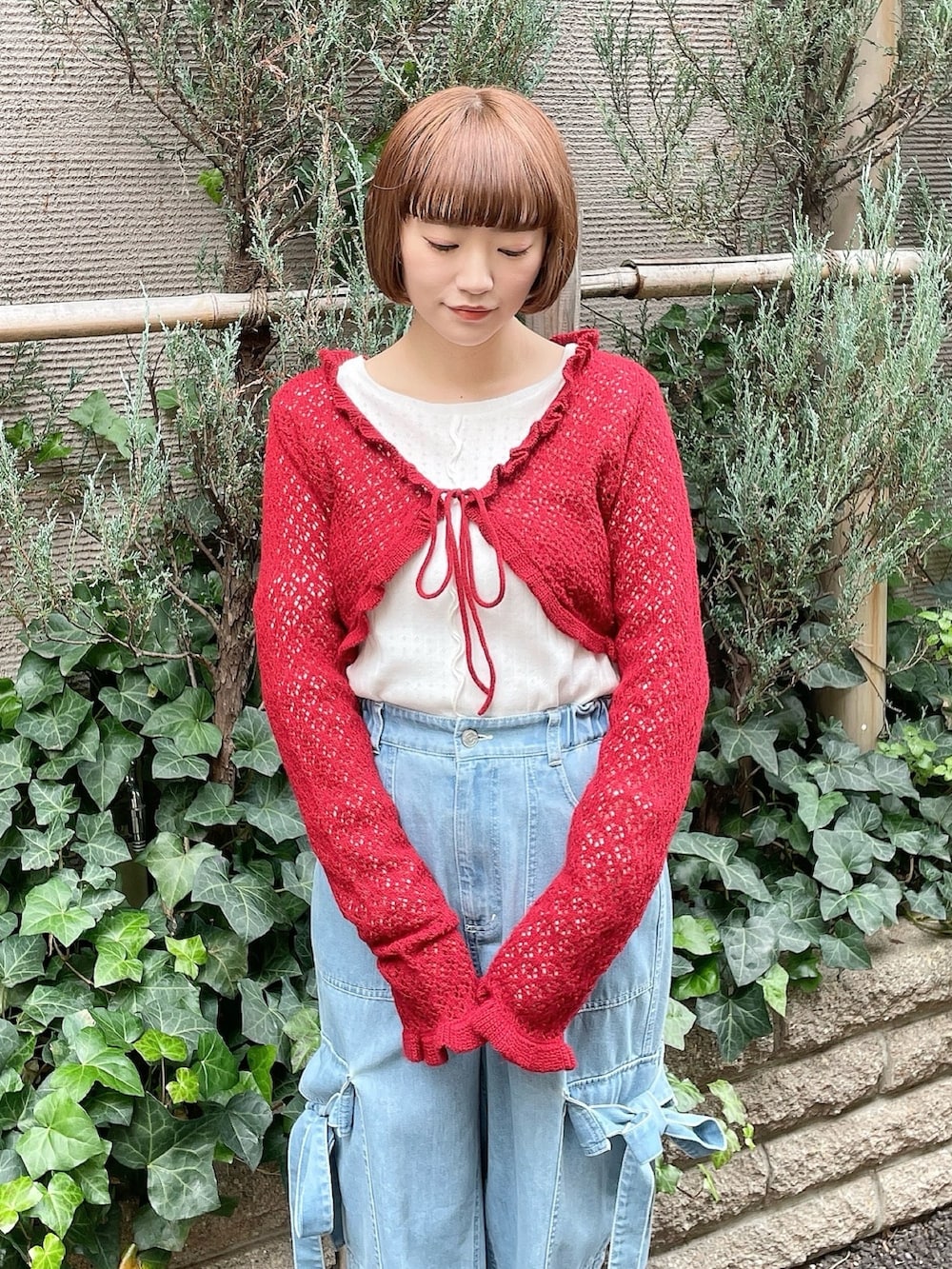 ブルー系のデニムパンツ、レッド系のカーディガン/ボレロ、ホワイト系のTシャツ/カットソーを着用したレディースの冬コーディネートの3枚目の写真