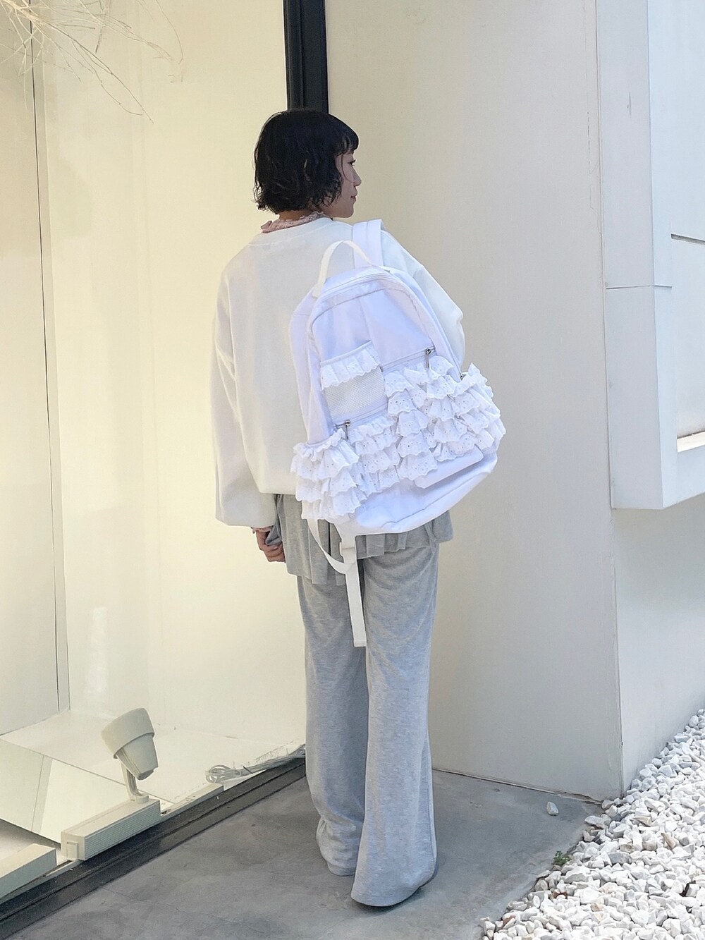 ホワイト系のバックパック/リュック、ホワイト系のスウェット、ピンク系のTシャツ/カットソーを着用したレディースの秋コーディネートの2枚目の写真