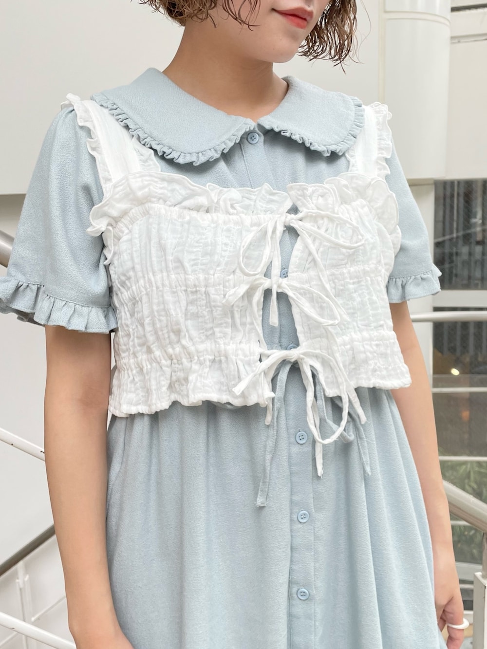 ホワイト系のベスト、ブルー系のワンピース、ホワイト系のサンダルを着用したレディースの夏コーディネートの4枚目の写真