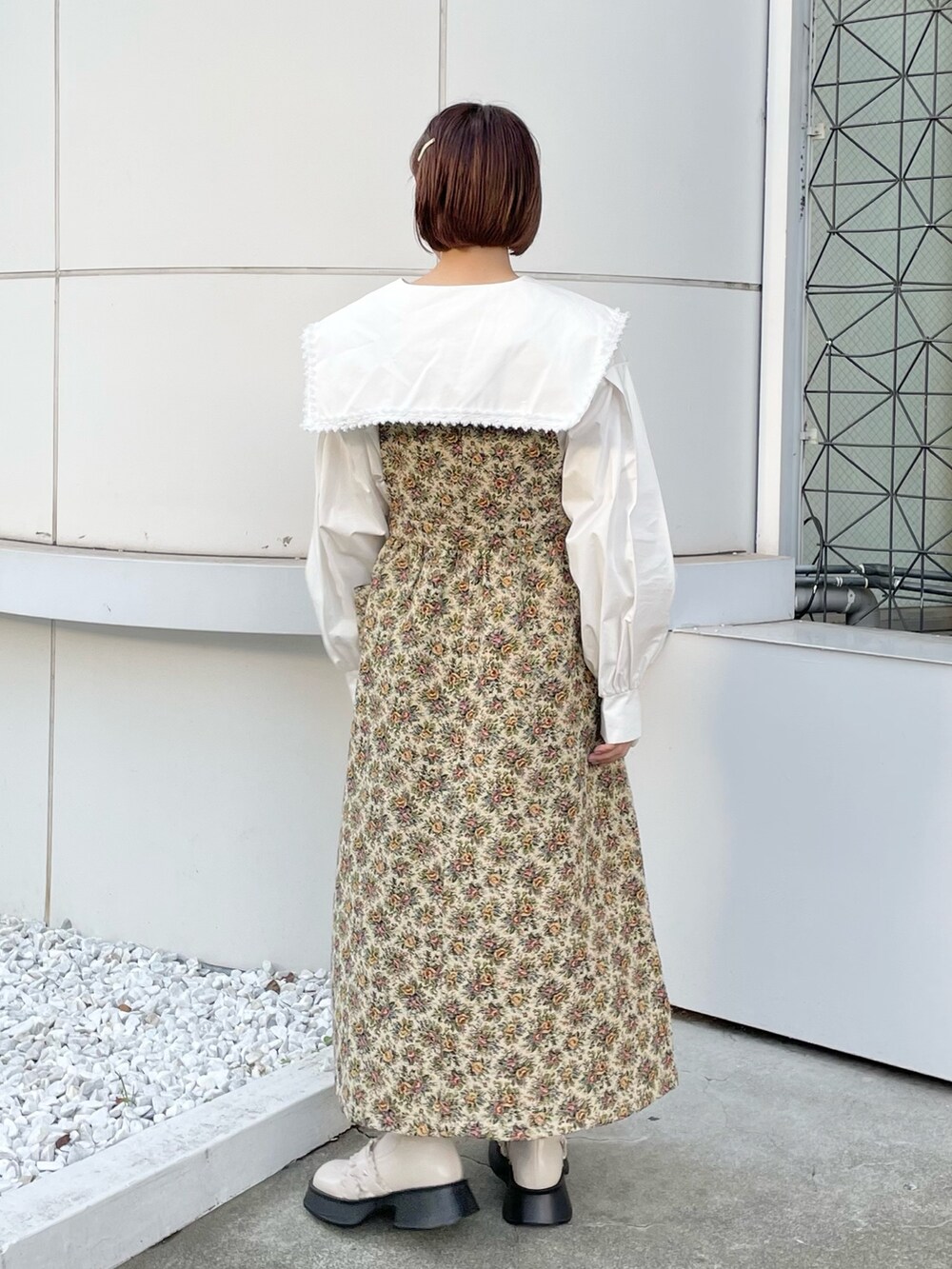 ホワイト系のシャツ/ブラウス、ベージュ系のジャンパースカート、ホワイト系のブーツを着用したレディースの秋コーディネートの3枚目の写真