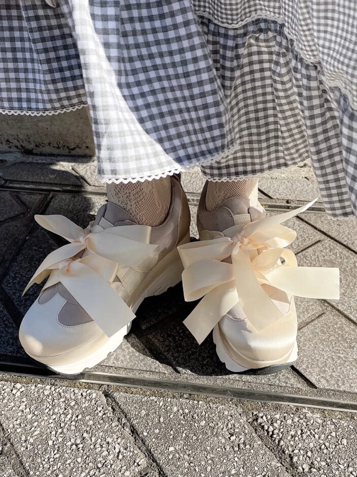 ホワイト系のトレンチコート、オレンジ系のシャツ/ブラウス、ブルー系のスカートを着用したレディースの冬コーディネートの8枚目の写真