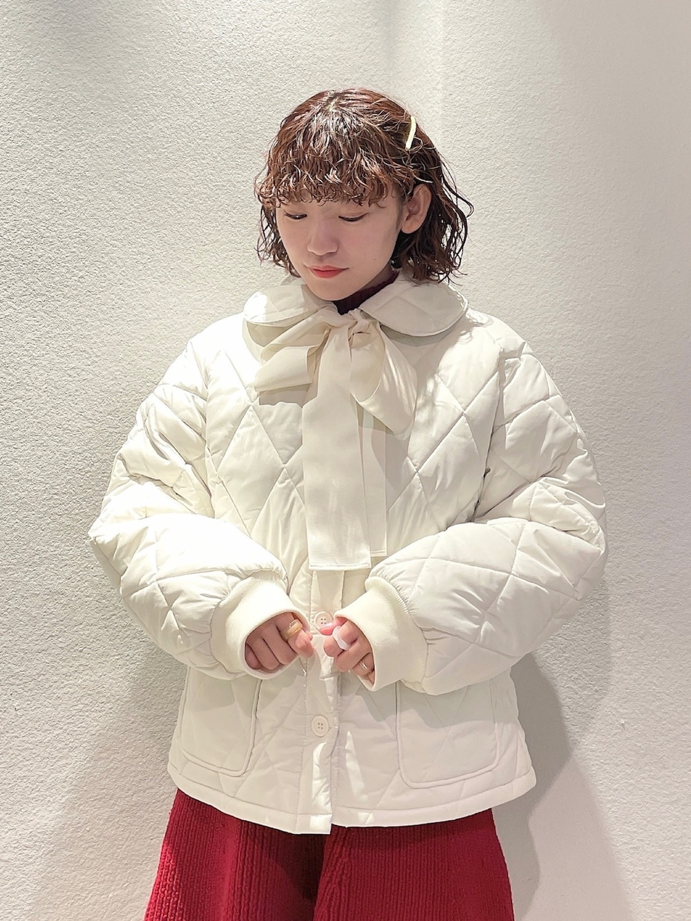 ホワイト系のその他アウター、レッド系のワンピース、ベージュ系のブーツを着用したレディースの冬コーディネートの3枚目の写真