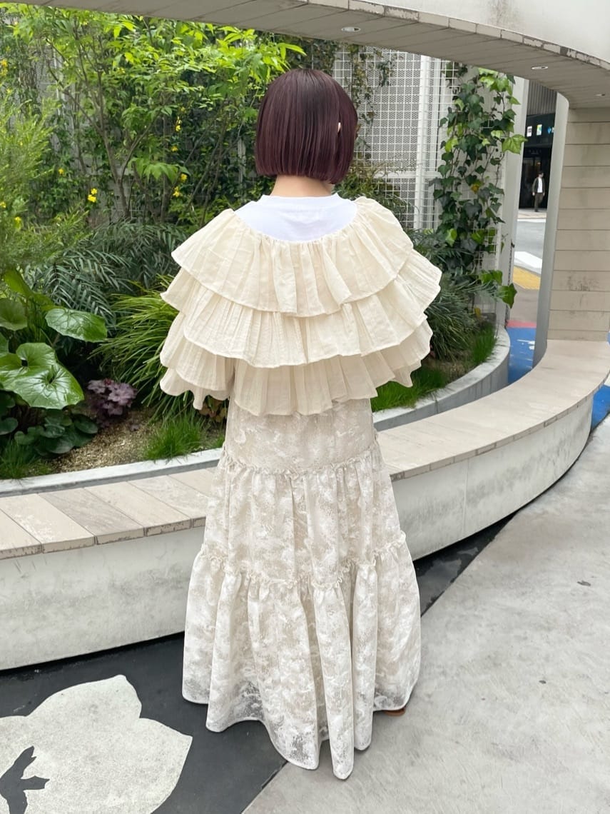 ベージュ系のスカート、ホワイト系のTシャツ/カットソー、ベージュ系のパンプスを着用したレディースの春コーディネートの3枚目の写真