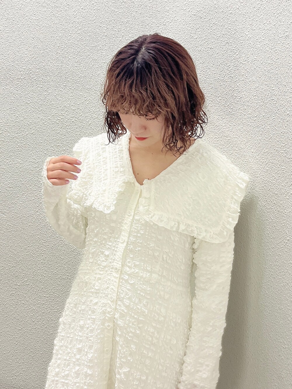 ホワイト系のワンピース、ベージュ系のトレンチコート、ホワイト系のパンプスを着用したレディースの冬コーディネートの8枚目の写真