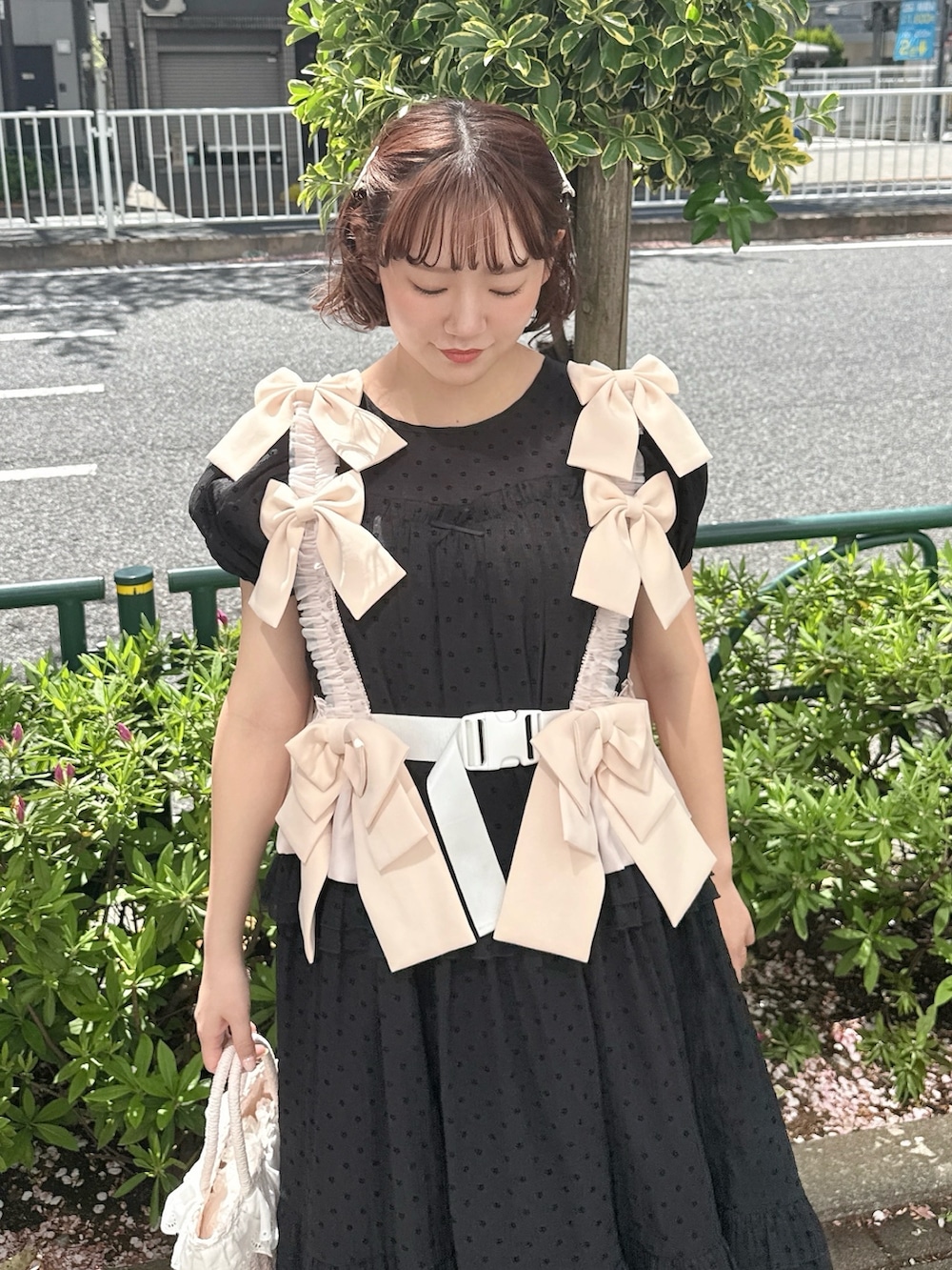 ブラック系のワンピース、ピンク系のハンドバッグ、ブラック系のバレエシューズを着用したレディースの春コーディネートの4枚目の写真