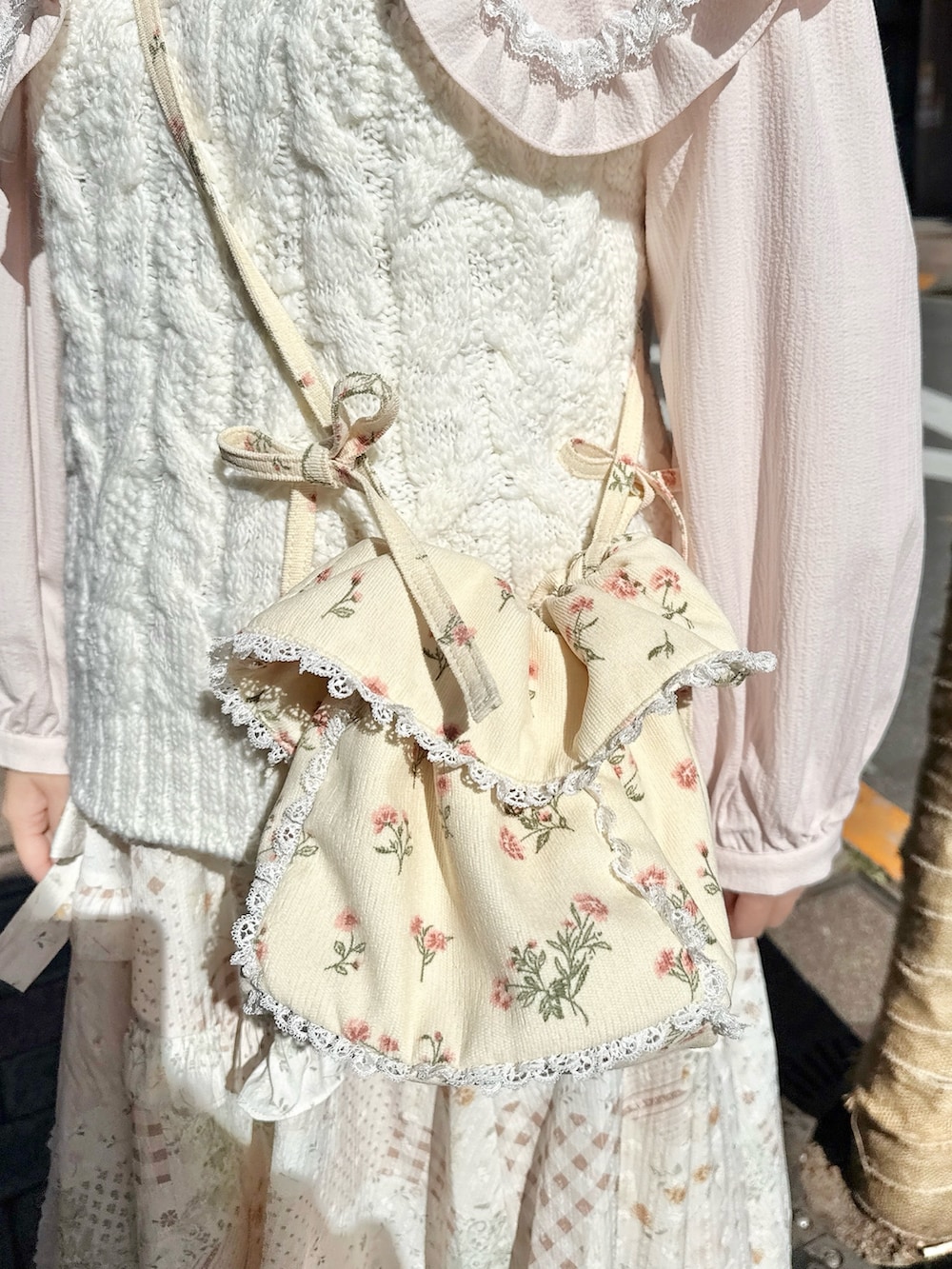 ピンク系のシャツ/ブラウス、ホワイト系のスカート、ホワイト系のショルダーバッグを着用したレディースの冬コーディネートの4枚目の写真