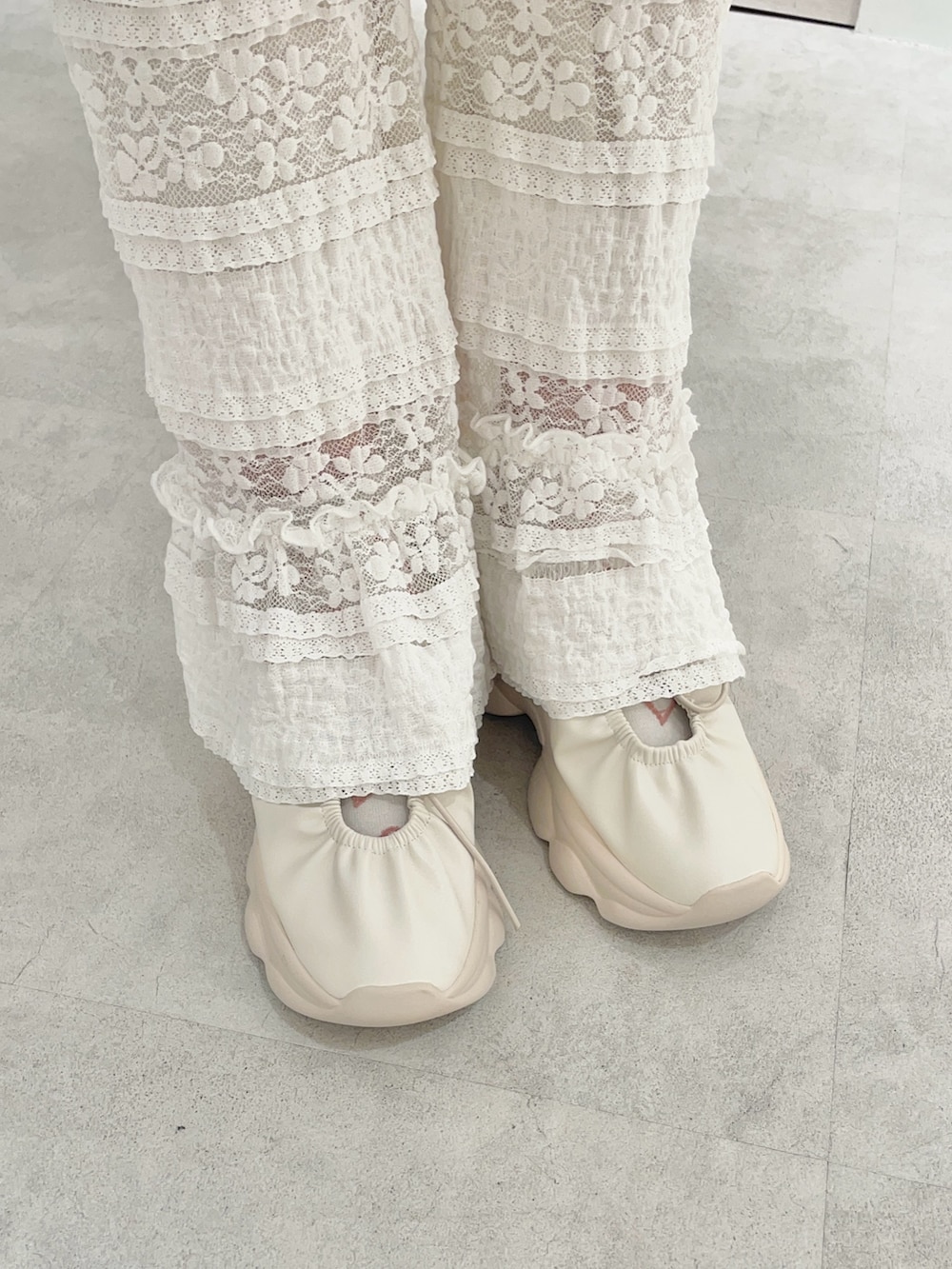 ホワイト系のスラックス、ホワイト系のTシャツ/カットソー、ピンク系のカーディガン/ボレロを着用したレディースの秋コーディネートの5枚目の写真